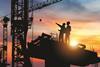 Building site cranes and workers silhouetted shutterstock_1588752748 JU.STOCKER